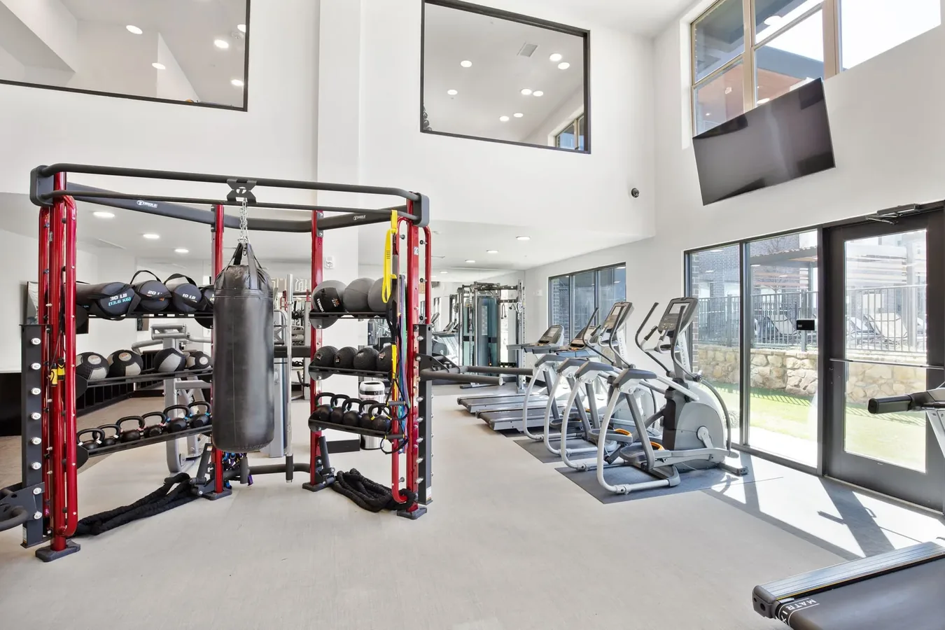 Fort Worth, Texas apartment gym with a Torque rig holding a heavy bag, medicine balls and kettlebells, and Matrix cardio
