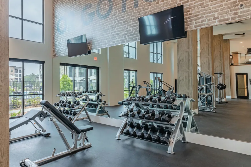 Free-weight area in a Colorado apartment gym with Spirit dumbbell racks, an incline bench and rubber flooring