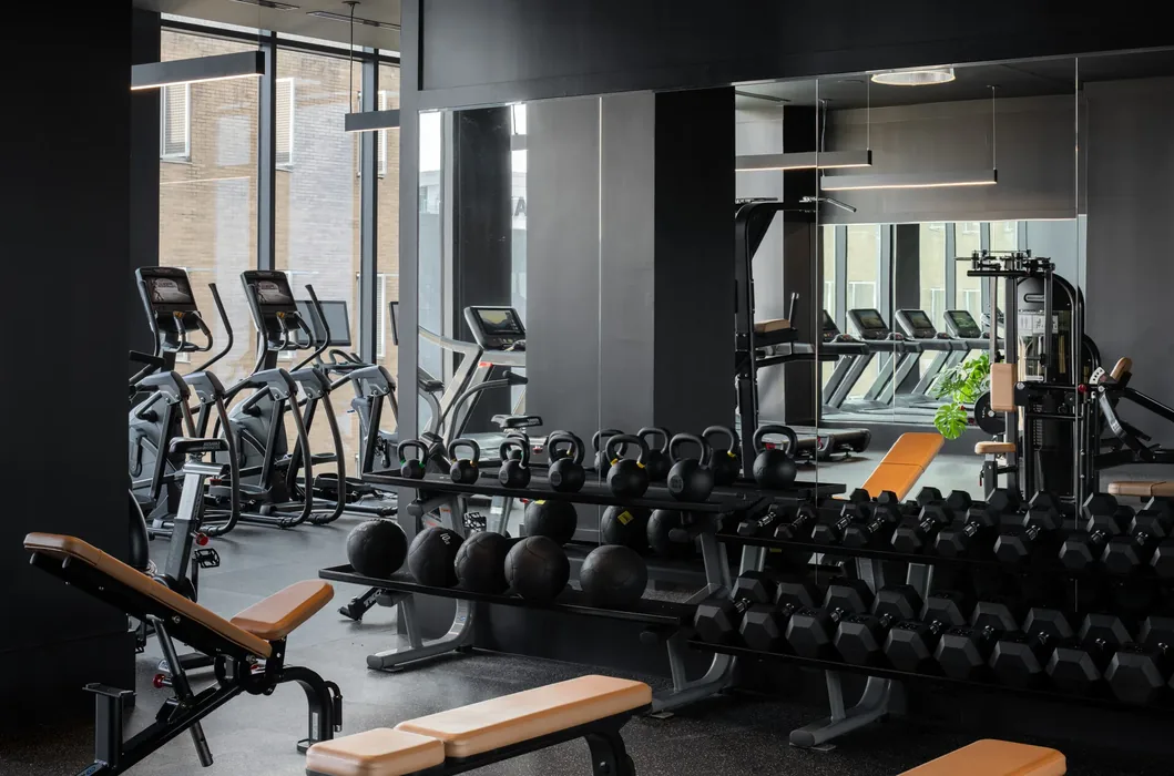 Free-weight area in an Atlanta, Georgia apartment gym with hex dumbbells, kettlebells, medicine balls and benches