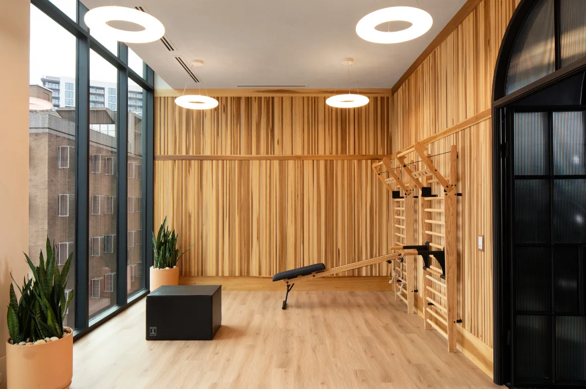 Stretching room in an Atlanta, Georgia apartment gym with wall bars, an incline bench and a plyo box on wood-look floor