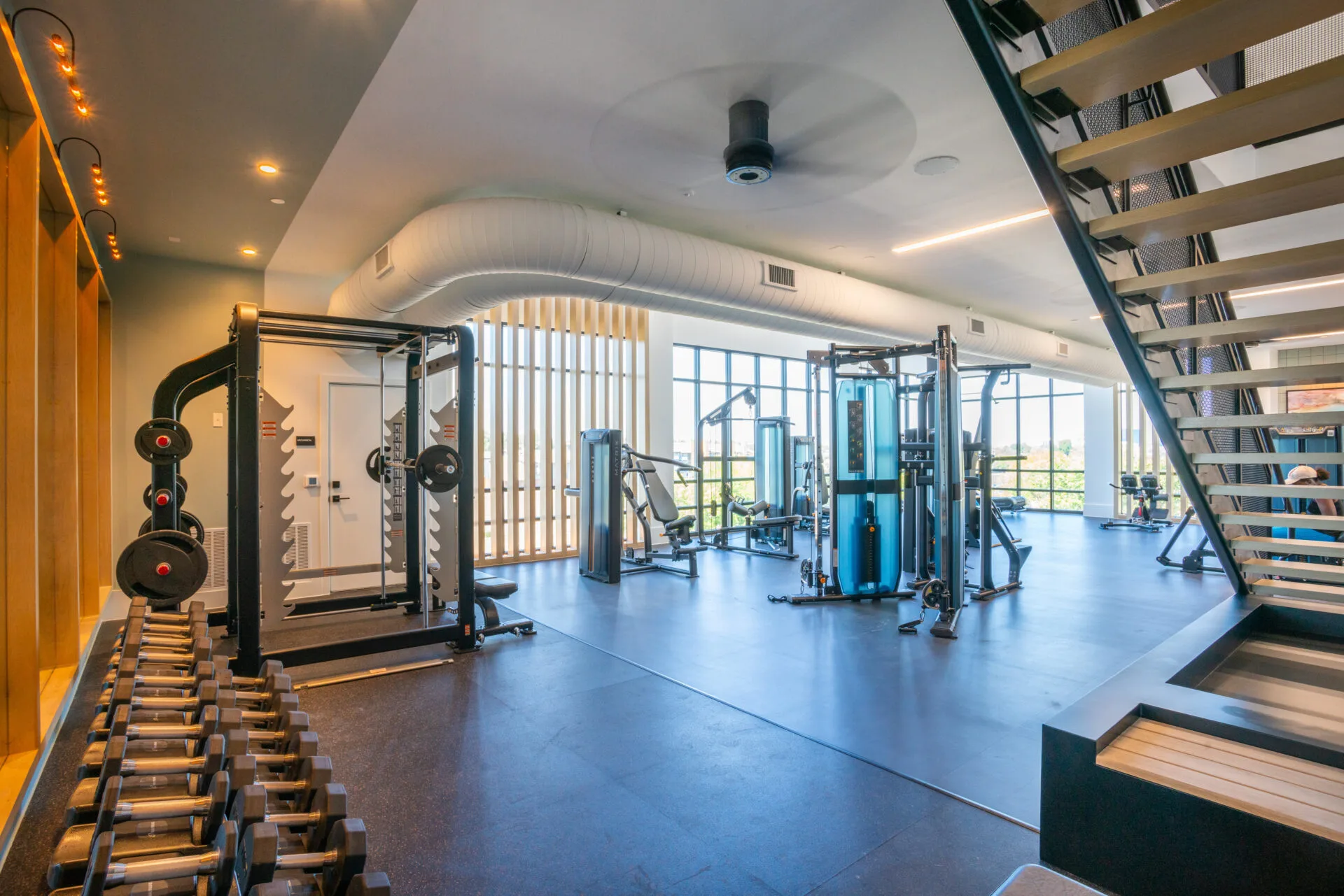 Selectorized strength machines and a dumbbell rack in a Texas apartment amenity gym