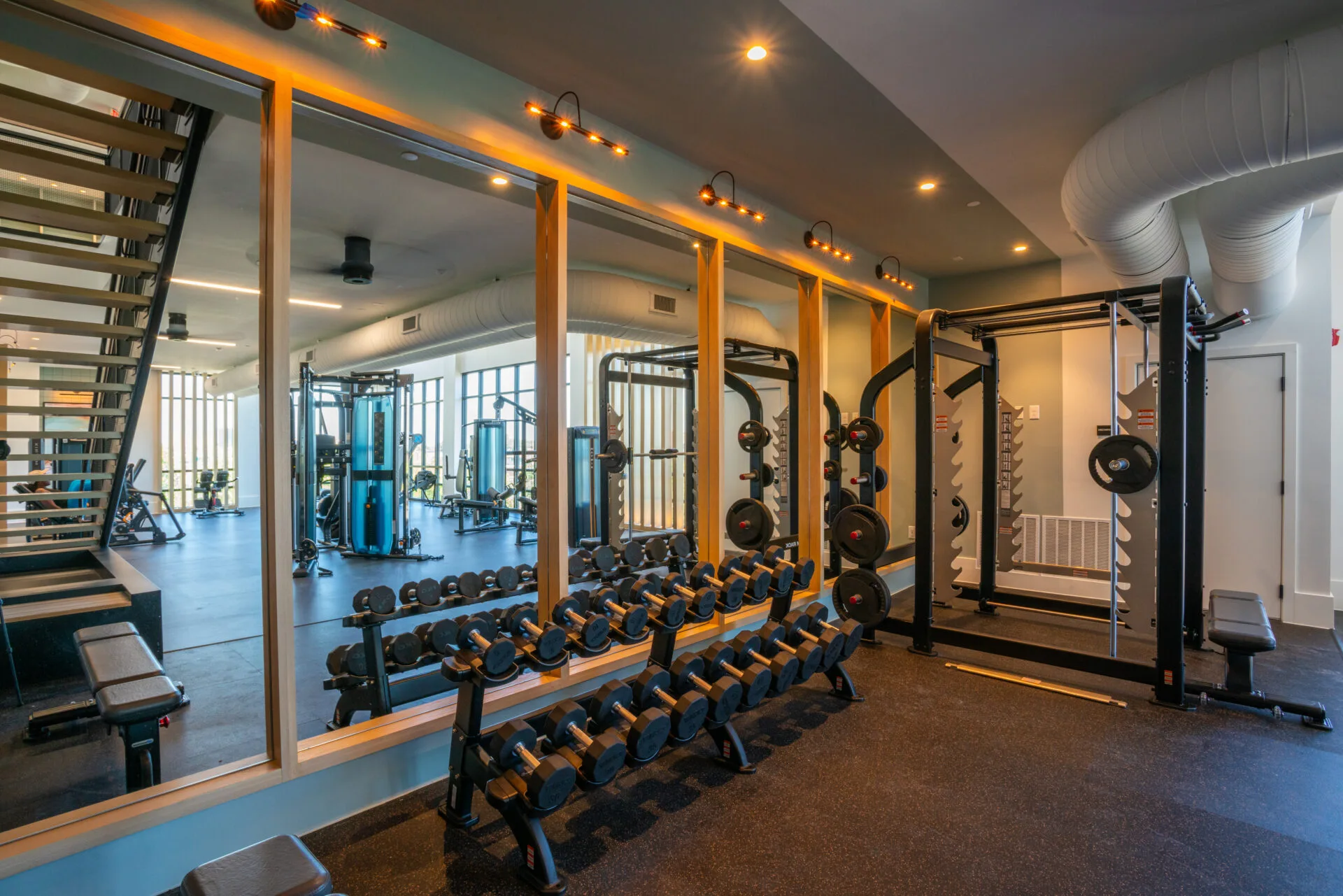 Free-weight area in a Texas apartment gym with a hex dumbbell rack, power rack and rubber flooring