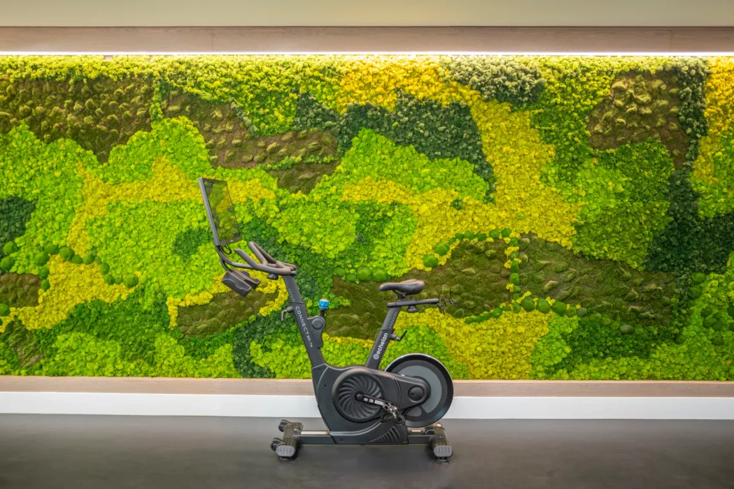 Echelon Connect indoor cycle against a preserved moss wall in a Dallas, Texas apartment gym