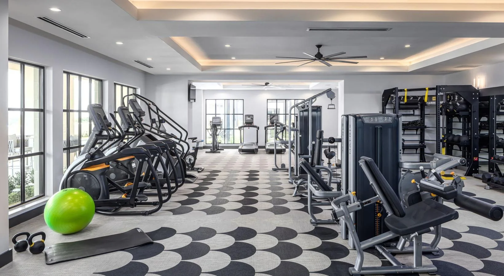 Apartment amenity gym in Dallas, Texas, with Matrix ellipticals and a functional training rack