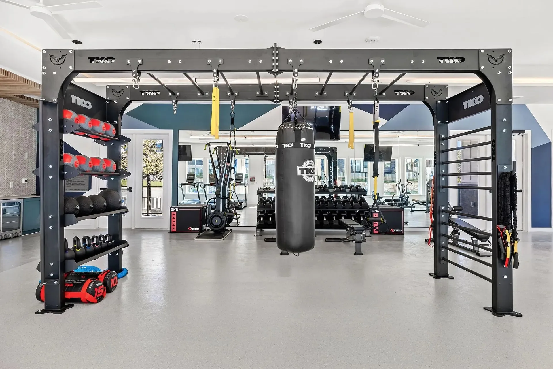 TKO functional rig in an Austin, Texas apartment gym with a heavy bag, medicine balls, kettlebells and wall bars