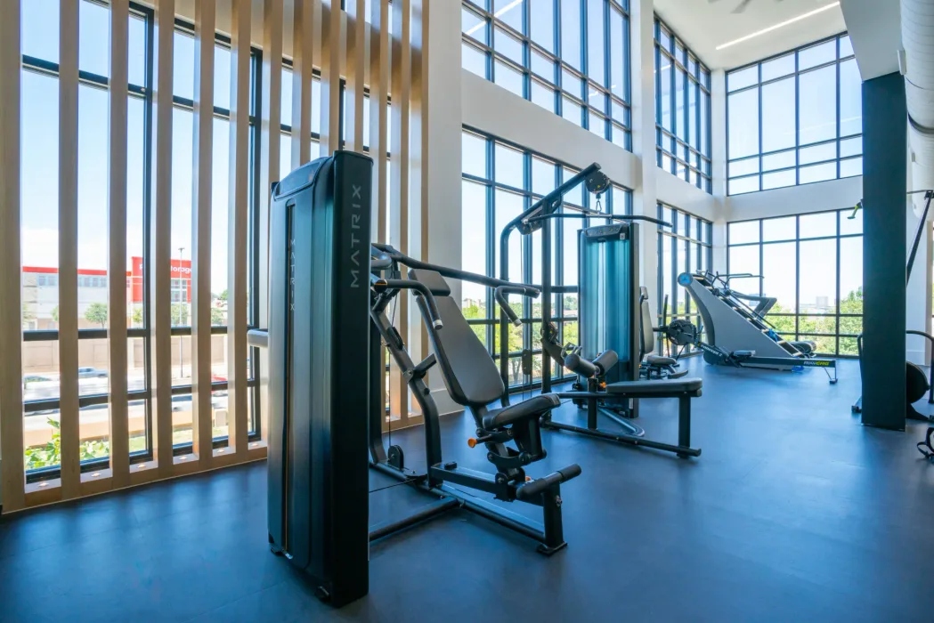 Strength area in a Texas apartment gym with Matrix chest press and leg machines and a Concept2 RowERG
