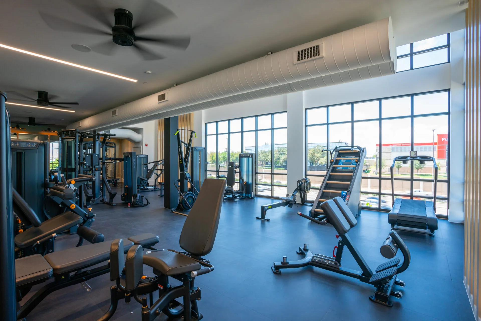 Strength area in a Texas apartment gym with Matrix leg and chest machines and a Concept2 RowERG
