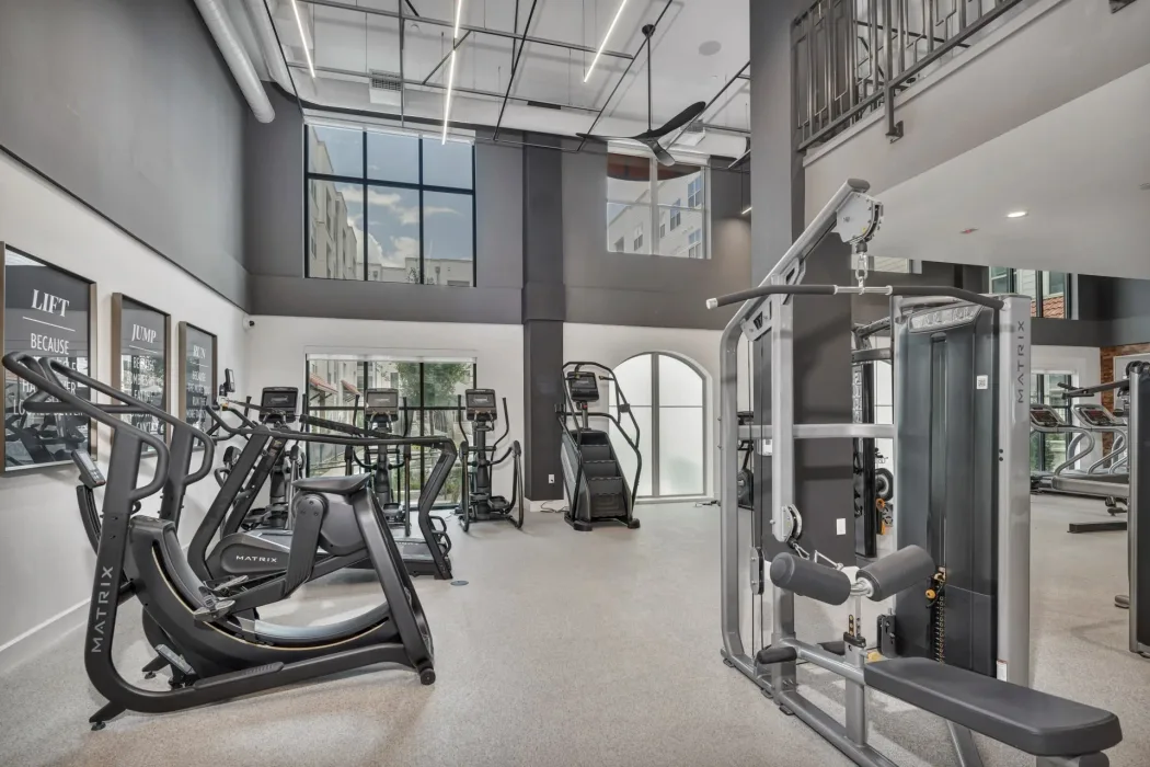Two-story Texas apartment gym with a Matrix selectorized cable machine and Matrix cardio equipment