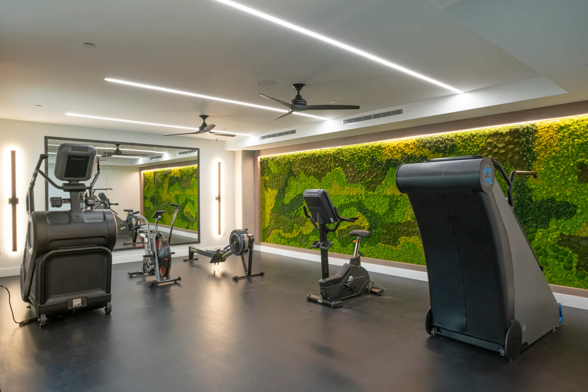Cardio room in a Dallas, Texas apartment gym with a stair climber, air bike, Concept2 rower and Matrix bike