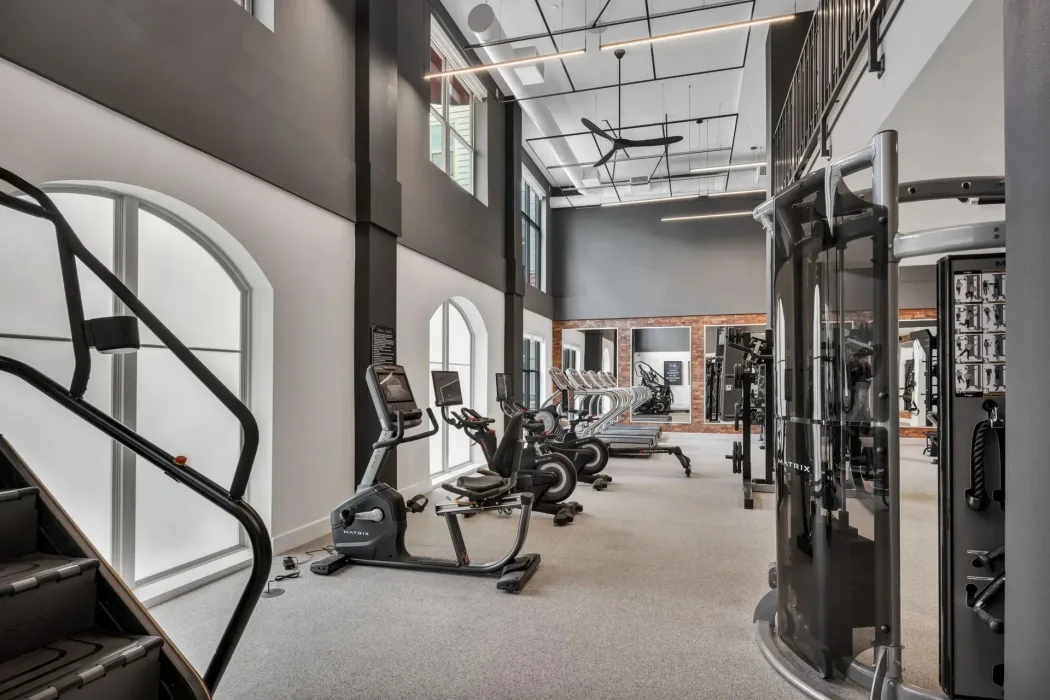 Double-height apartment gym in Texas with Matrix recumbent and Echelon bikes, treadmills and a functional trainer