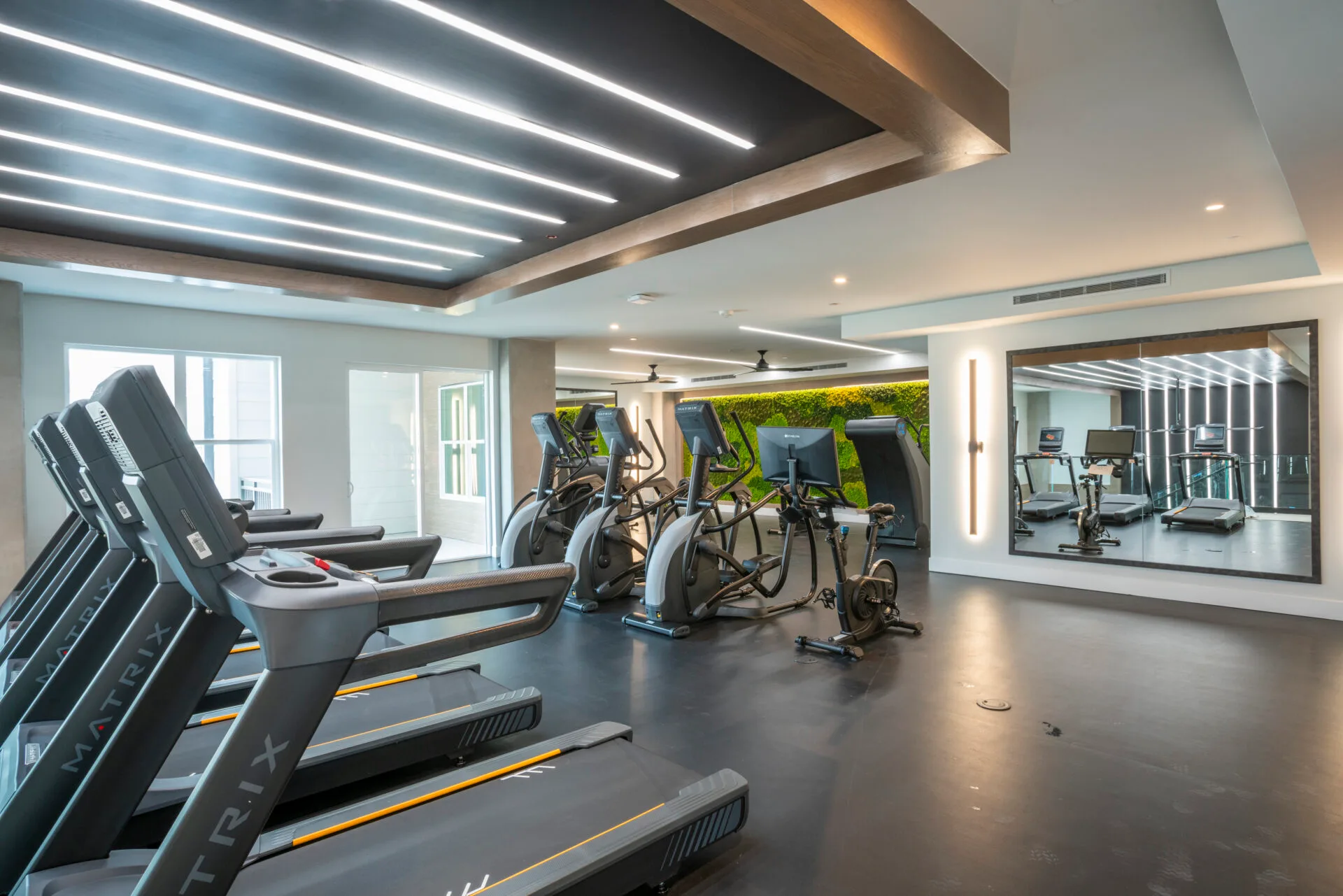 Cardio room in a Dallas, Texas apartment gym with Matrix treadmills and ellipticals on rubber flooring