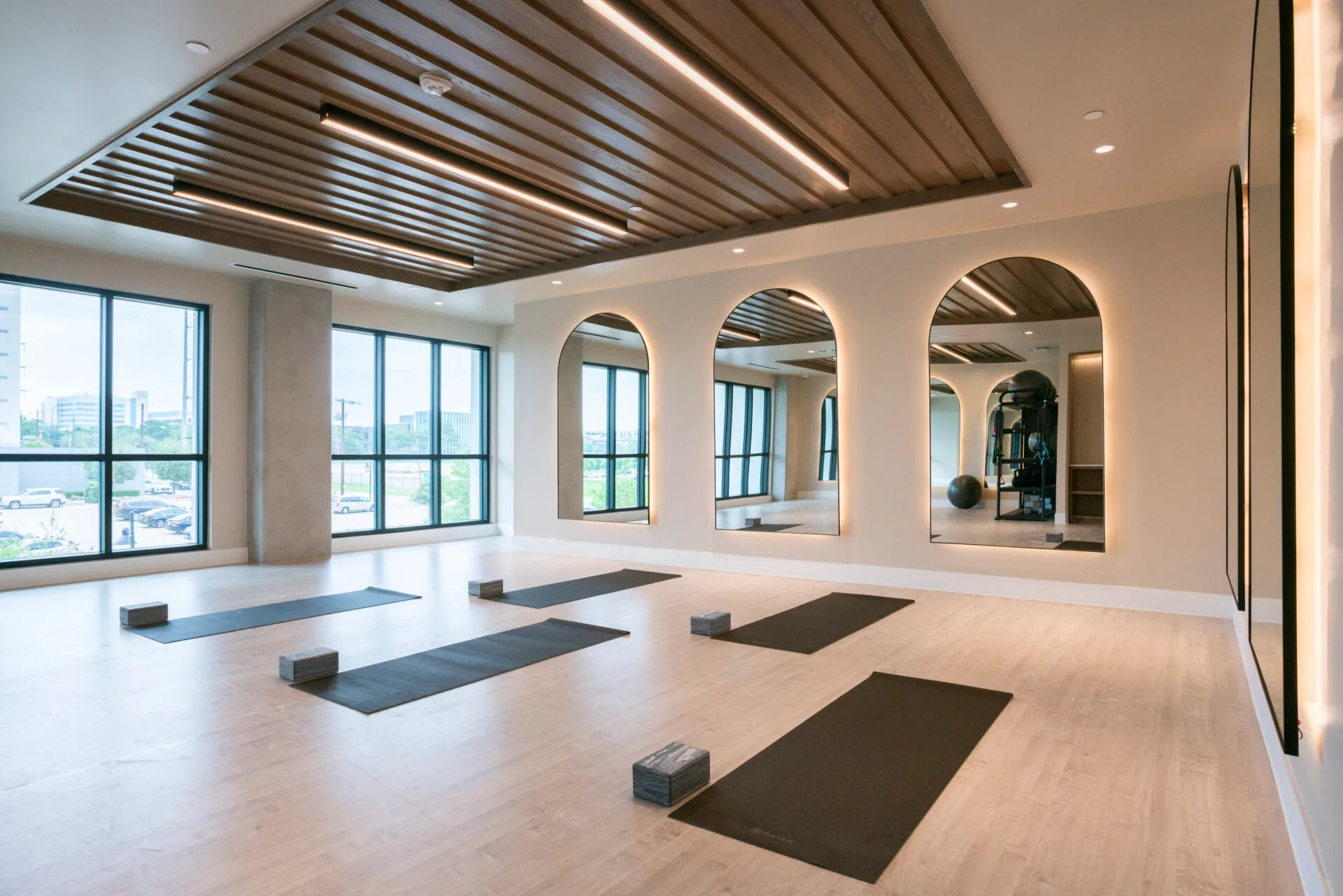 Yoga studio in a Dallas, Texas apartment community with exercise mats, foam blocks and arched backlit mirrors