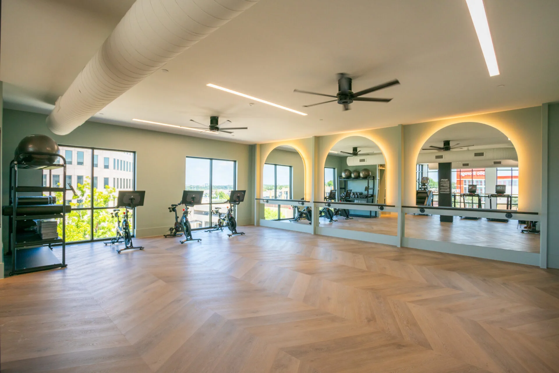 Group studio in a Texas apartment community with a ballet barre, backlit mirrors and indoor cycling bikes