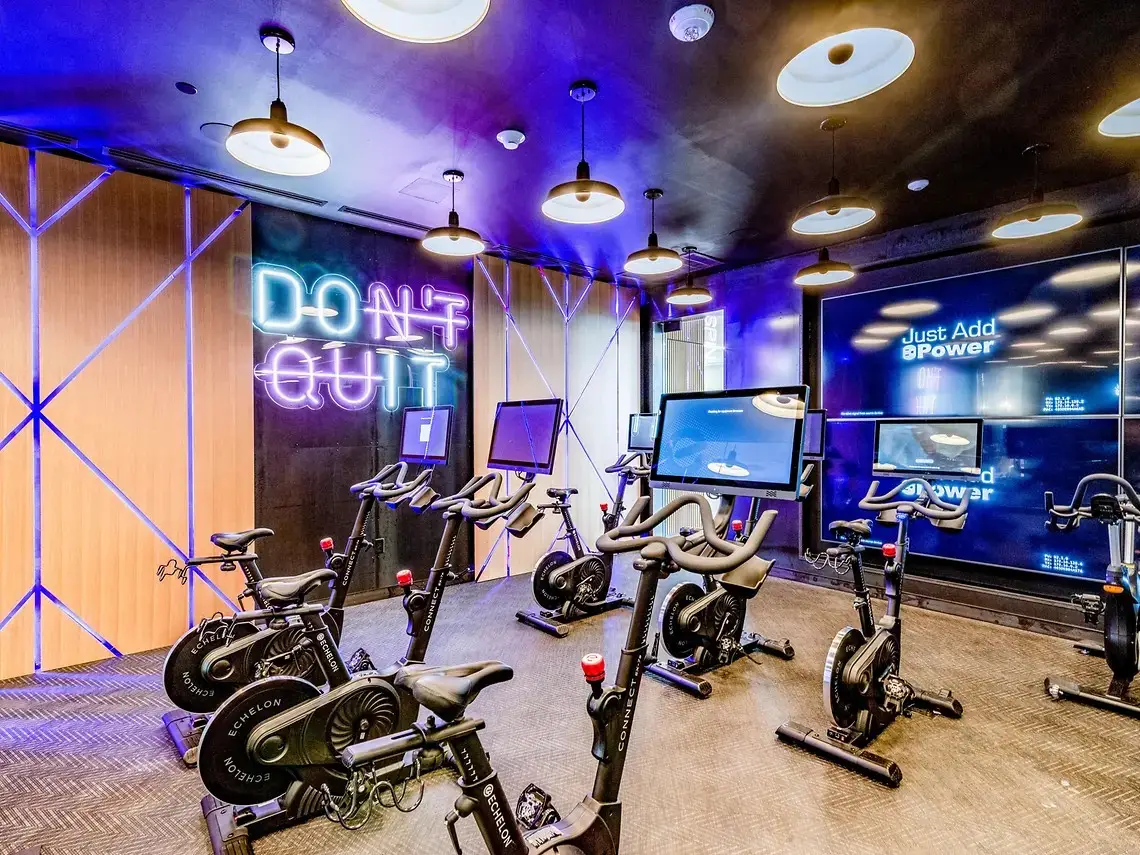 Indoor cycling studio in Austin, Texas student housing with Echelon Connect bikes and screens