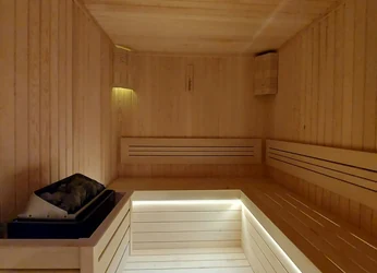 Interior of a commercial sauna with tiered timber benches and low lighting
