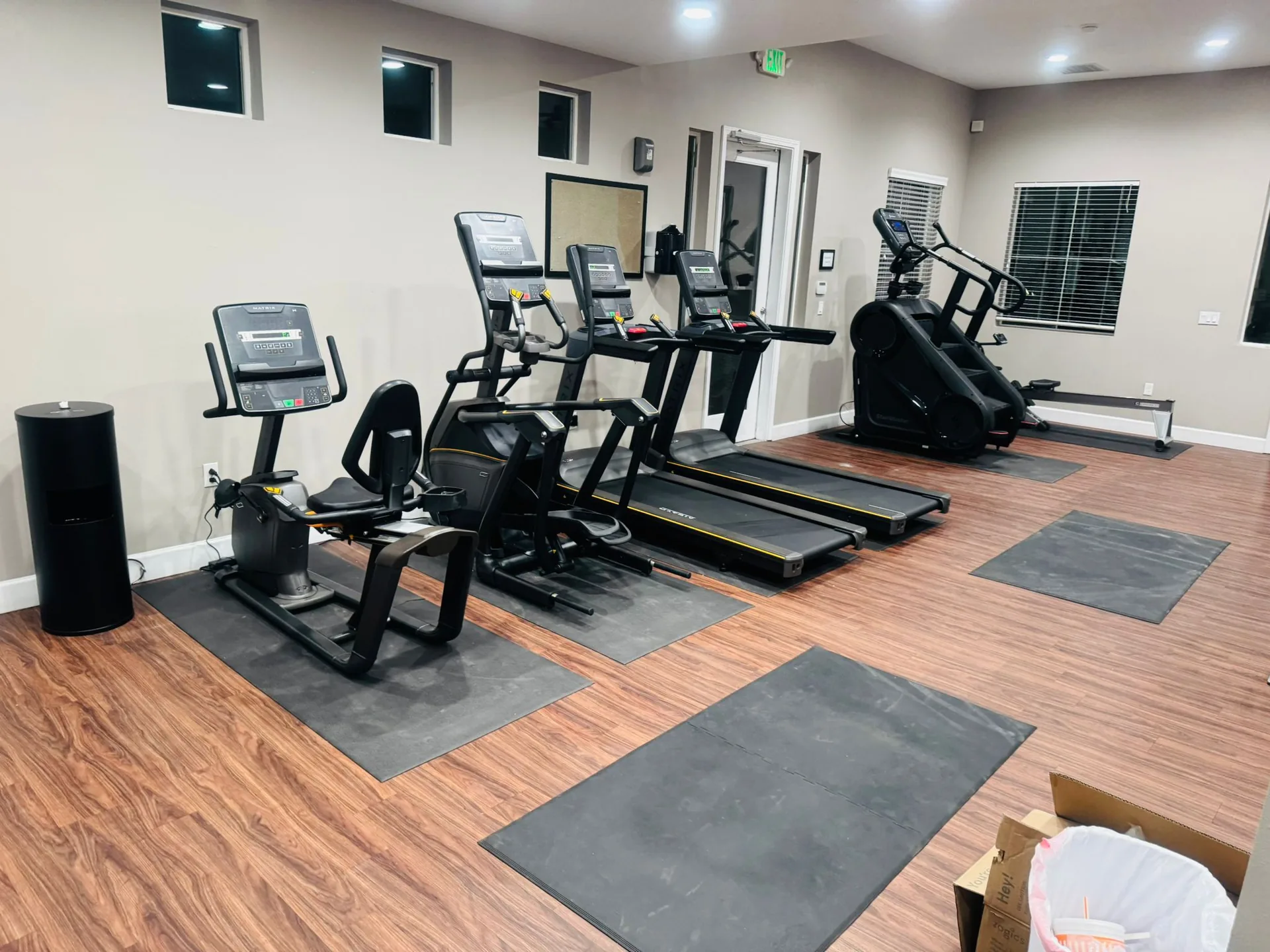 Cardio equipment being set out during installation at an Albuquerque apartment gym, packaging still on the floor