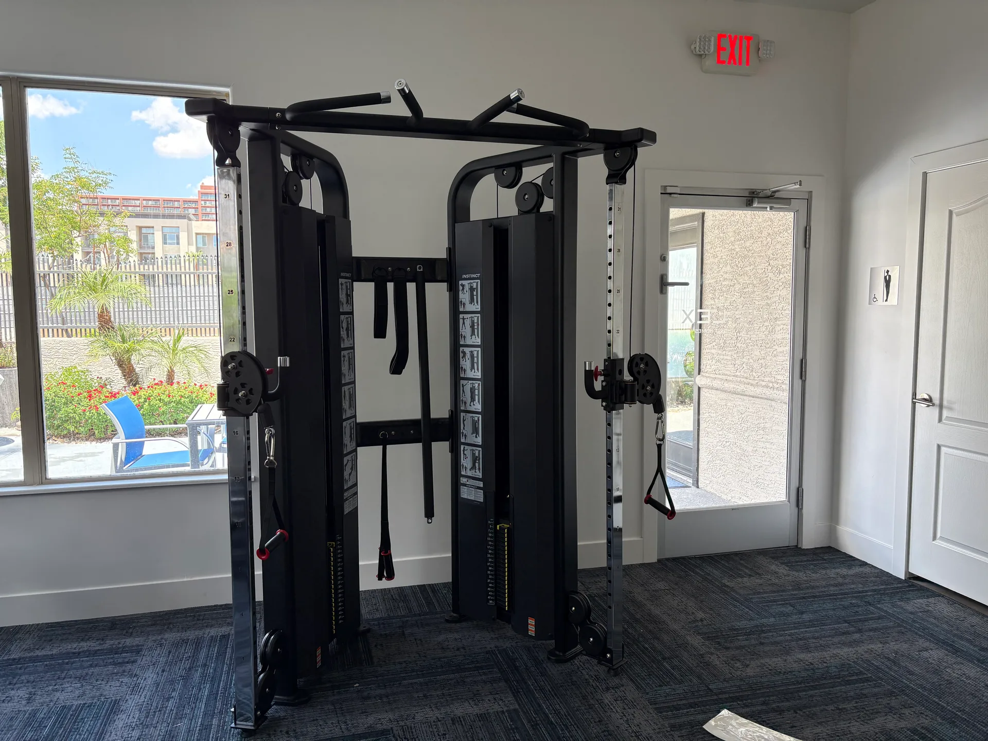 Two-tower cable functional trainer with an integrated pull-up bar at an Arizona apartment amenity gym