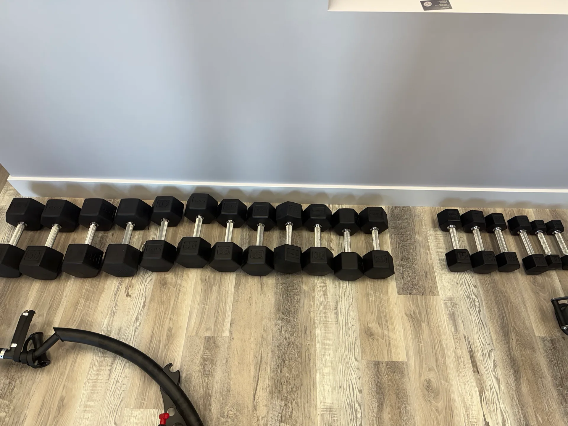 Wall-mounted rack of rubber hex dumbbells at an Arizona apartment amenity gym