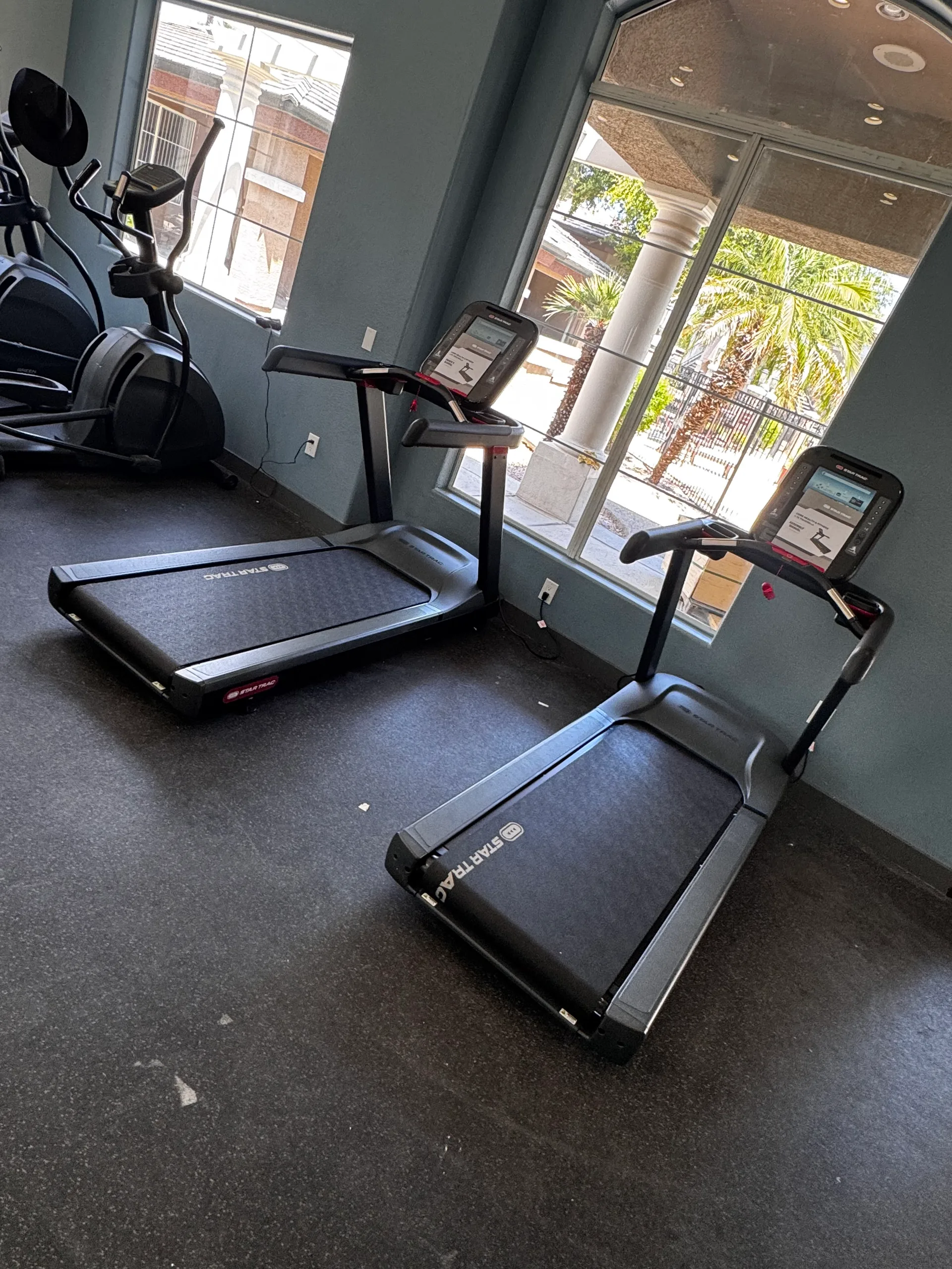 Two Star Trac treadmills facing windows over the courtyard at an Arizona apartment amenity gym