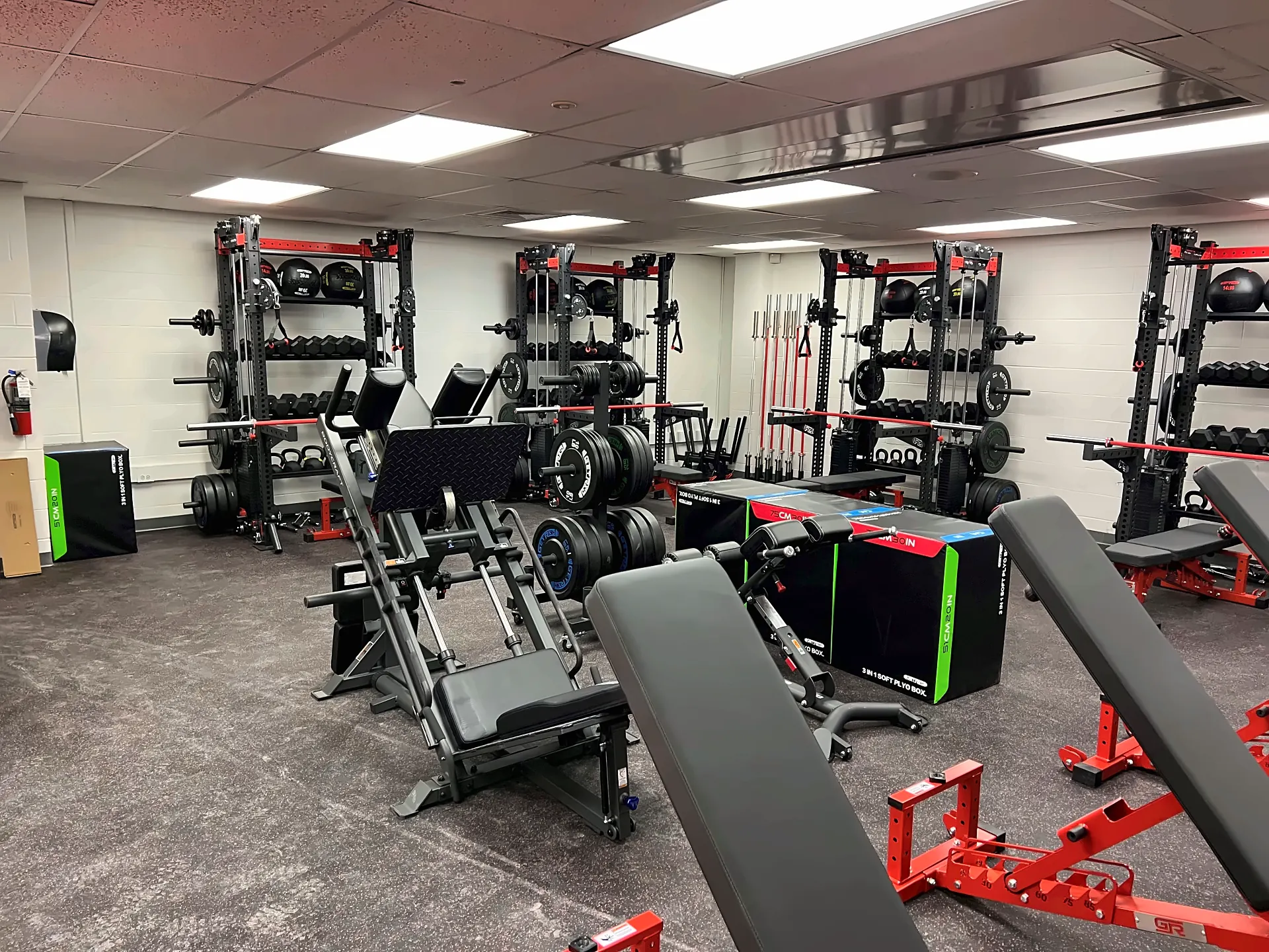 Saranac High School weight room in Saranac, NY: red adjustable benches, plyo boxes and racks with storage