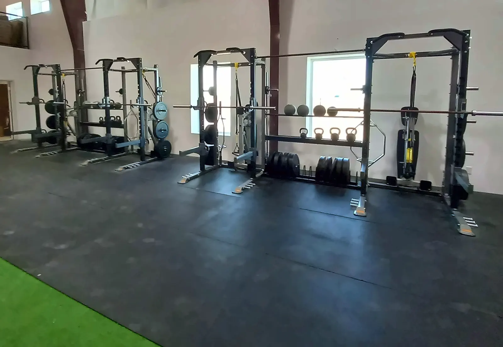Fieldhouse Fitness Center in Northlake, TX: power racks with med balls, kettlebells and plates on a rubber floor