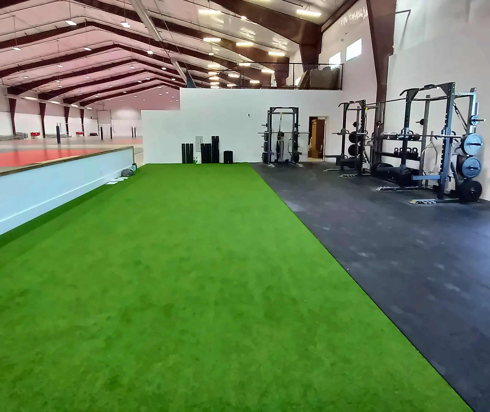 Fieldhouse Fitness Center in Northlake, TX: a long turf lane beside a rubber floor with power racks