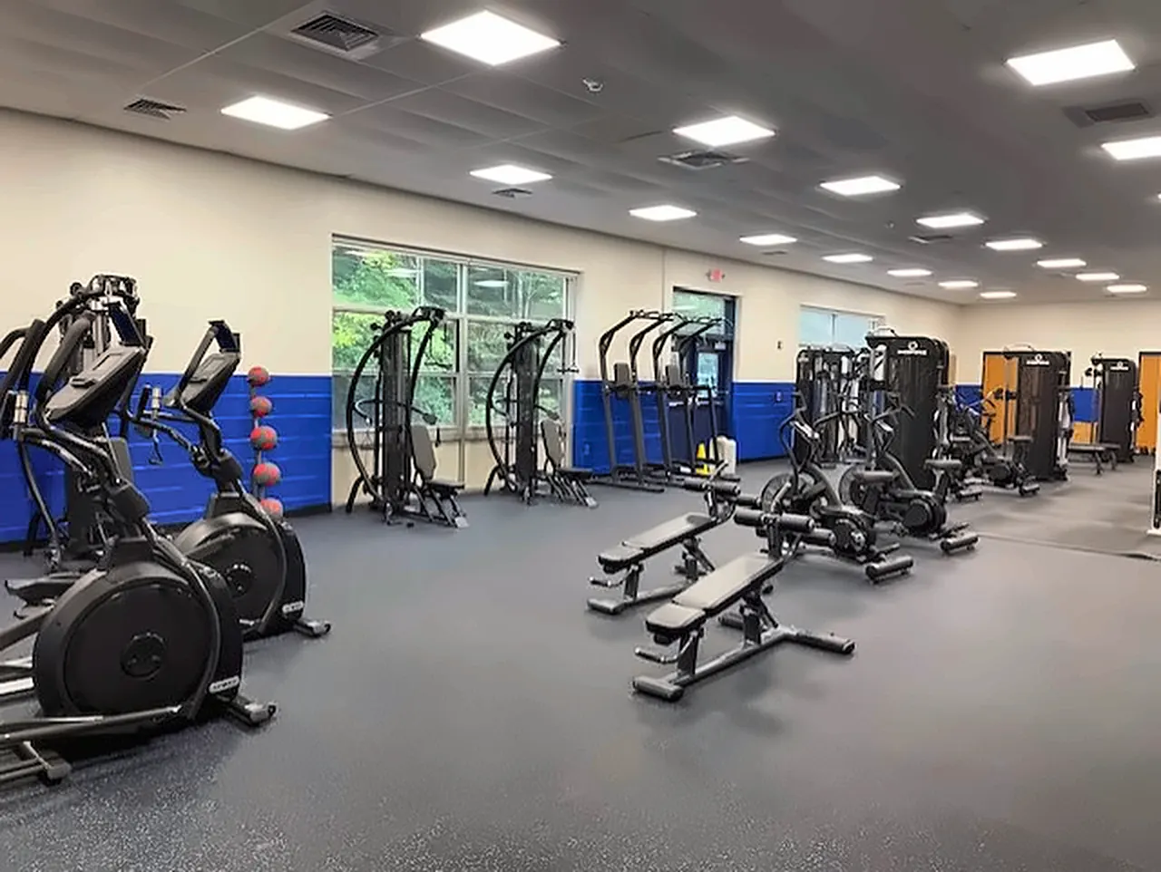 Essex Middle School fitness room in Vermont: ellipticals, cable stations, adjustable benches and medicine balls