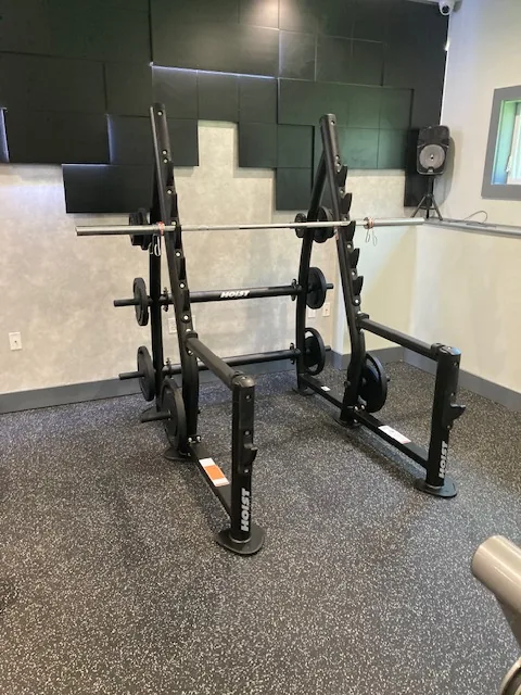 Squat rack with an Olympic bar and benches at a Danbury, Connecticut apartment gym