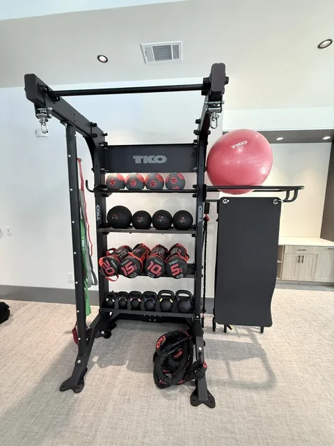 TKO functional storage rack with medicine balls, kettlebells, a stability ball and a battle rope