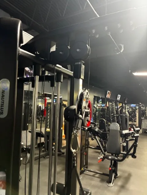 Nautilus cable machine beside a seated leg extension at a Jacksonville, Florida commercial gym