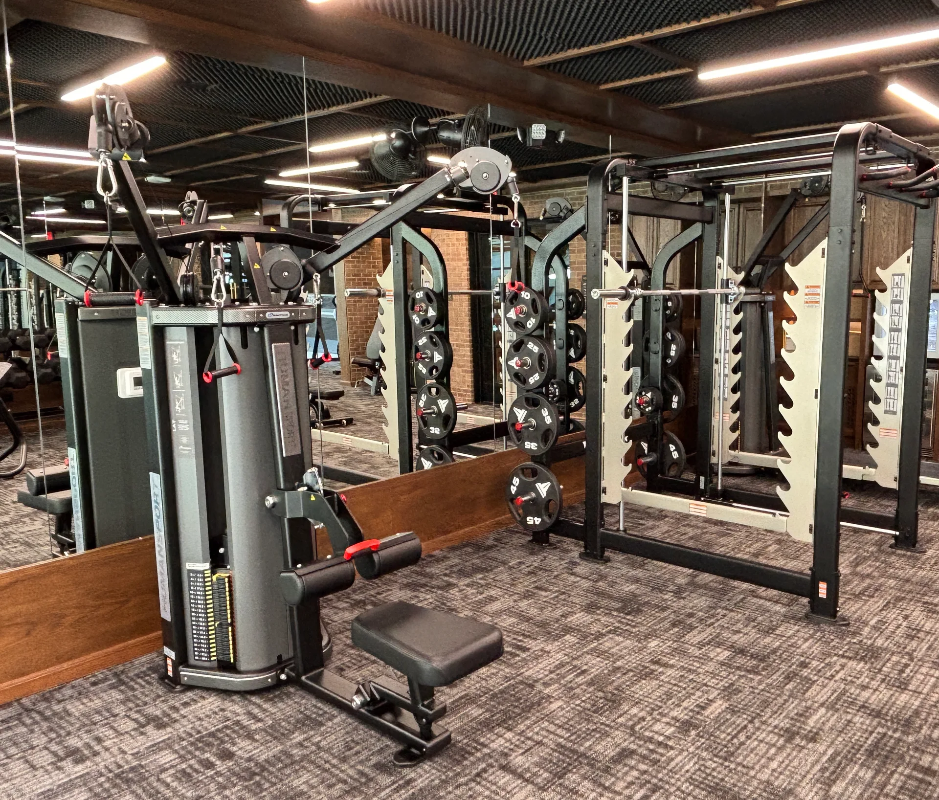 Instinct cable station and Freedom racks with plate storage against brick in a Mansfield, Texas apartment gym