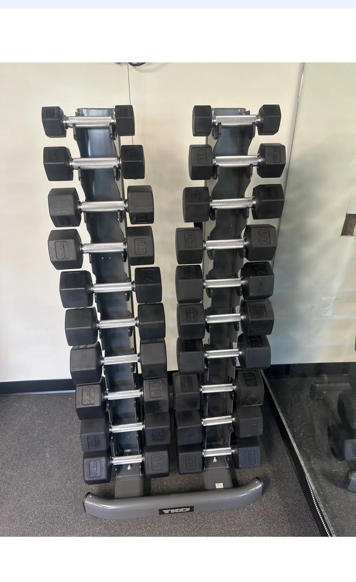 Two-tower vertical dumbbell rack beside a mirrored wall at a Nottingham, Maryland apartment gym