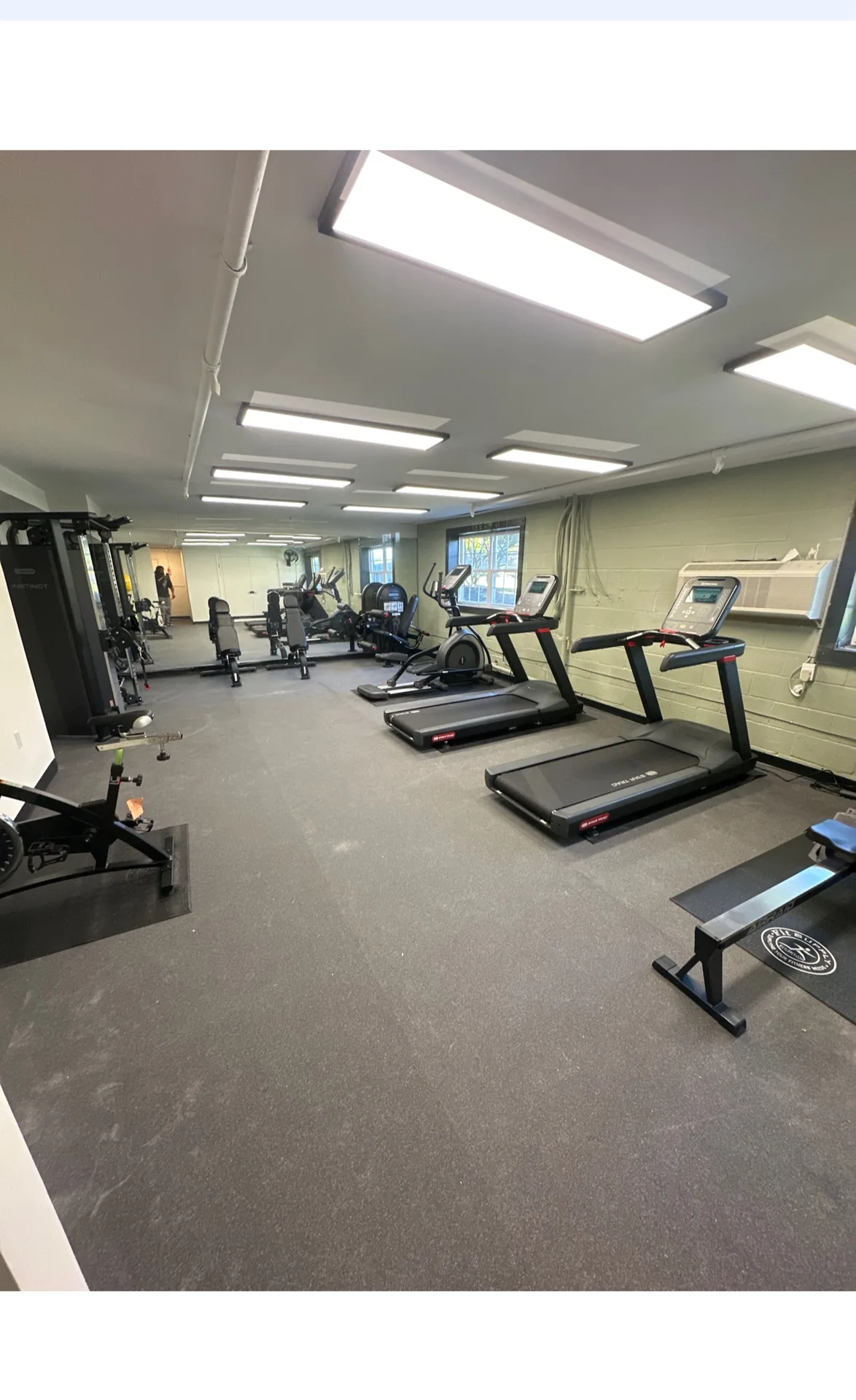 Treadmills and a bench along a mirrored wall at a Nottingham, Maryland apartment gym