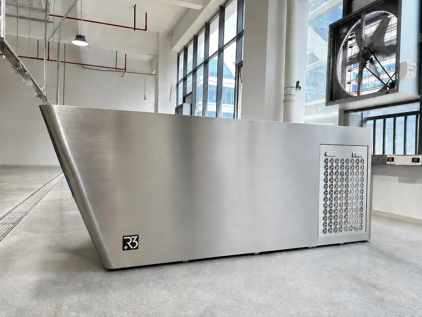 Stainless steel commercial cold plunge installed in a fitness facility, with the chiller housed in the surround