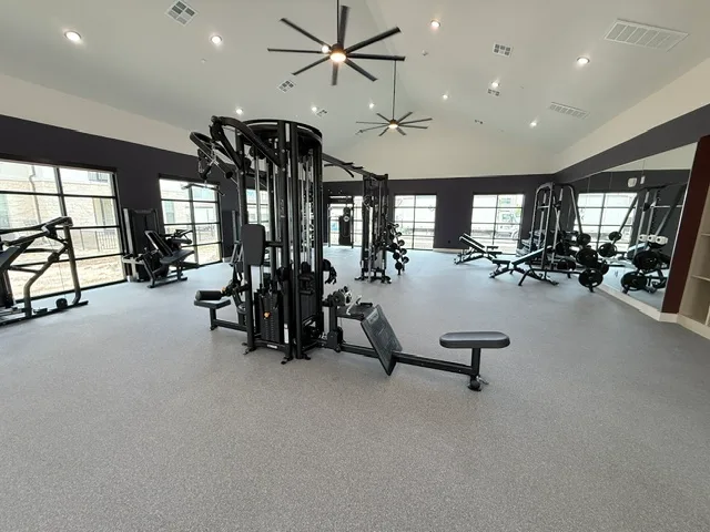 Matrix Aura multi-station, a Smith machine and benches under a vaulted ceiling in a Spring, Texas apartment gym