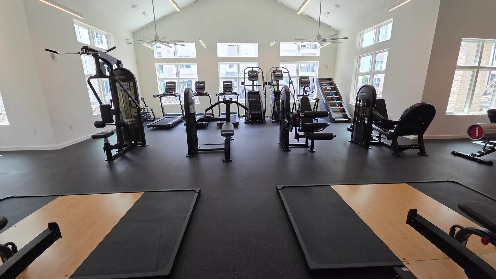 Instinct strength floor facing a window wall with lifting platforms in the foreground in a Webster, Texas apartment gym
