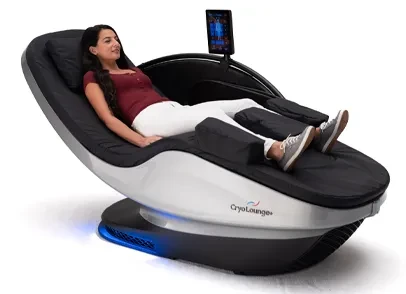 A woman reclining in a black and white CryoLounge+ contrast-therapy chair with a touchscreen arm