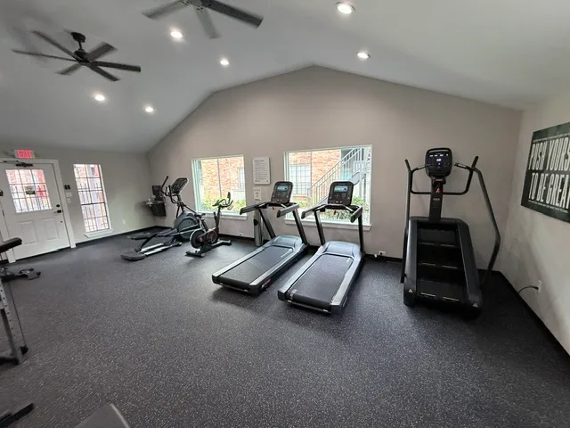 Treadmills, a stair climber and ellipticals under a vaulted ceiling in an apartment gym in The Woodlands, Texas
