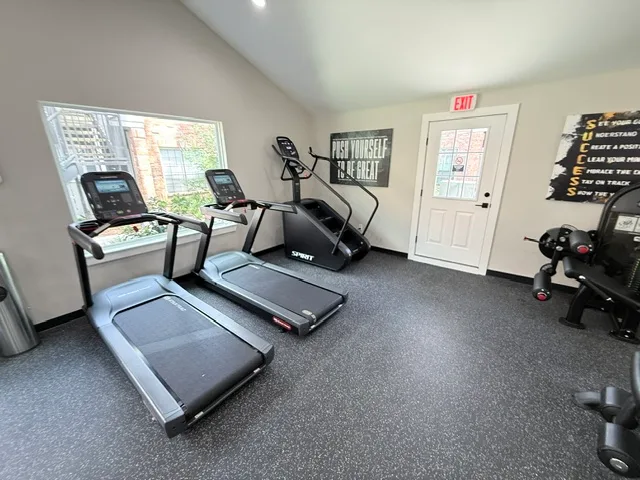 Two Star Trac treadmills and a Spirit stair climber by a window in an apartment gym in The Woodlands, Texas