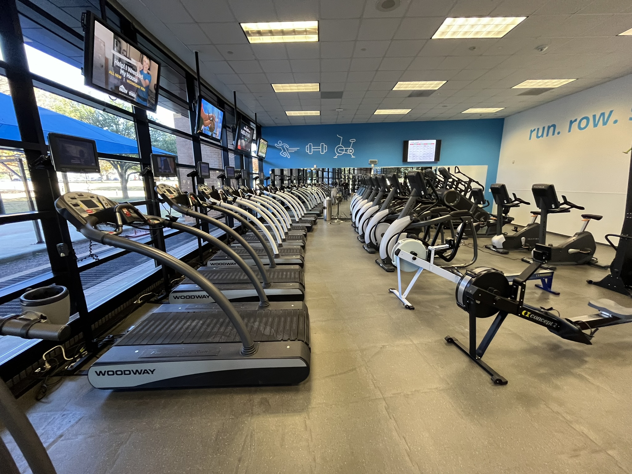 Custom-designed apartment gym with treadmills, ellipticals, and weight training area